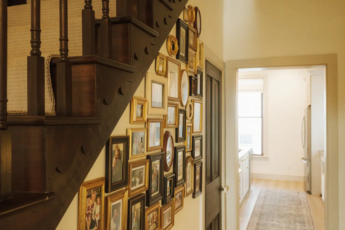 Staircase lined with a gallery wall of gilded frames